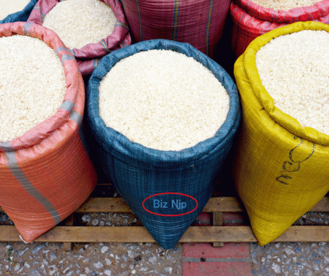 Industrial stack of white PP laminated woven sacks for moisture-resistant agricultural rice storage in a warehouse facility